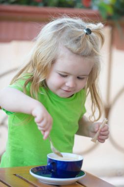 Çocuk çocuk şeker mavi Kupası'nda karıştırma.