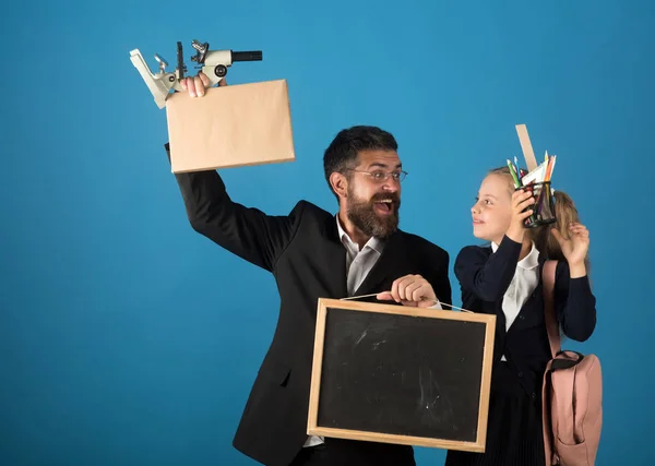 Kind und Lehrer halten Schulmaterial und Tafel in der Hand — Stockfoto