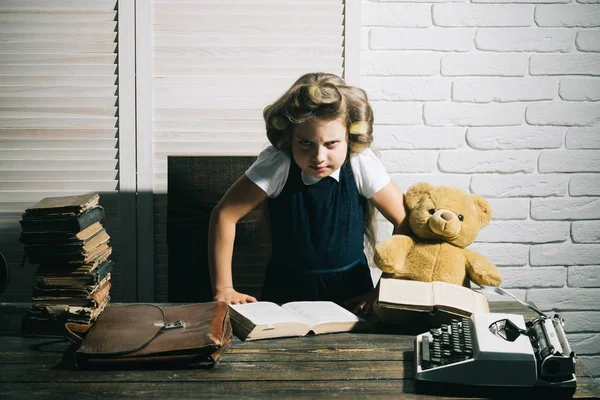 Küçük kız kıvırıcı saç ile kitap okumak.