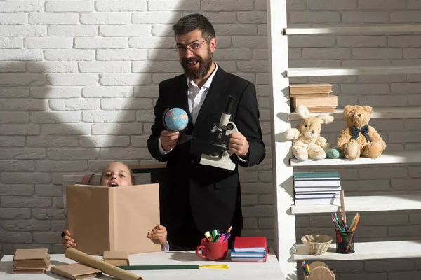 Kız öğrenci ve öğretmen mutlu yüzler ile açık kitap tutun