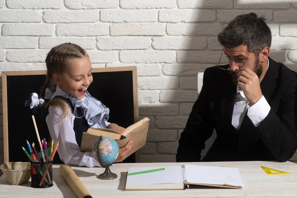 Filha e pai em sala de aula sobre fundo de tijolo branco — Fotografia de Stock