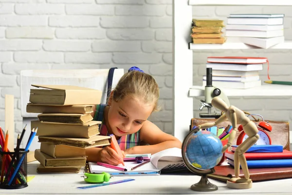 Konsantre yüz ile kız öğrenci sanat kitapta çizer