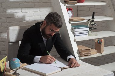 Profesör ciddi bir yüz ile bardaklarda kitapta yazıyor