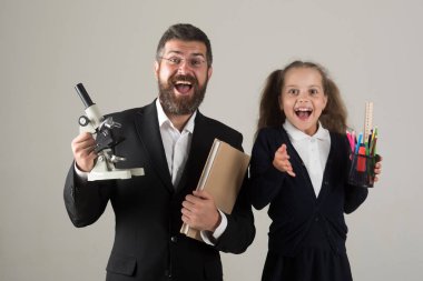 Baba ve gri arka plan üzerinde iyimser yüzleri ile kız öğrenci