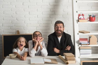 Kızlar ve sakallı adam kitaplarla masa başında oturmak