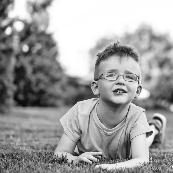 Felice bambino in occhiali su erba — Foto Stock