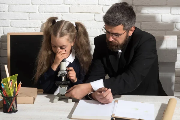 여자와 남자 책상에 앉아 현미경으로 보이는 — 스톡 사진