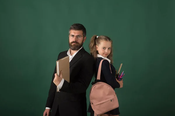 Homem de terno e menina com saco vestindo uniforme escolar — Fotografia de Stock