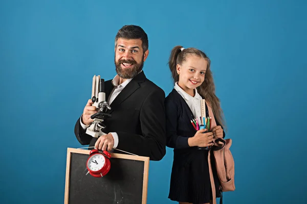 Homem com barba e rapariga de uniforme. Professor e estudante — Fotografia de Stock