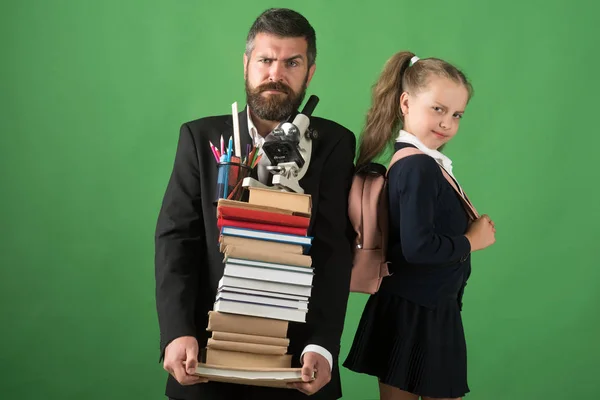 Kind und Betreuer halten Stapel Bücher und Schreibwaren in der Hand — Stockfoto