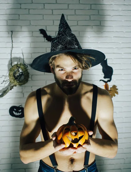 Hombre de Halloween en sombrero de bruja con calabaza — Foto de Stock