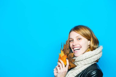 Kız mavi arka plan üzerinde turuncu yaprak ile.