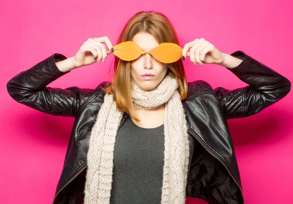 Ragazza con foglie arancioni su sfondo rosa . — Foto Stock