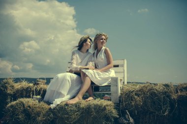 İki kız saman bankta kitap okuma