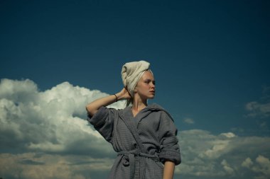 Bornozlu kadın ve kafasında havlu.