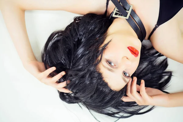 Kvinnan i svart peruk liggande uppochner — Stockfoto