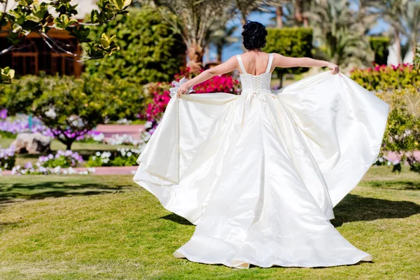 Woman waving wedding dress as wings