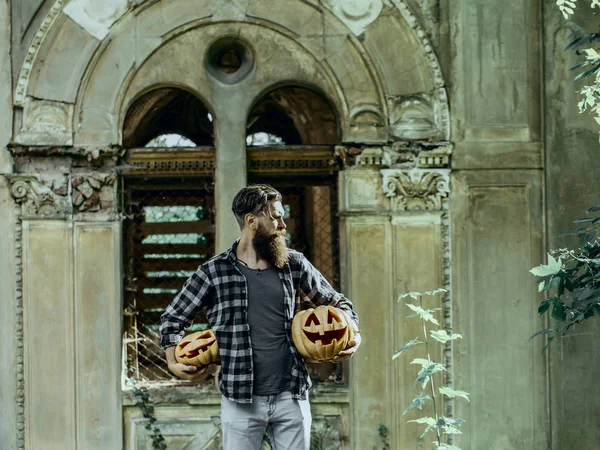 Halloween-Mann mit Kürbissen auf verlassenem Gebäude — Stockfoto