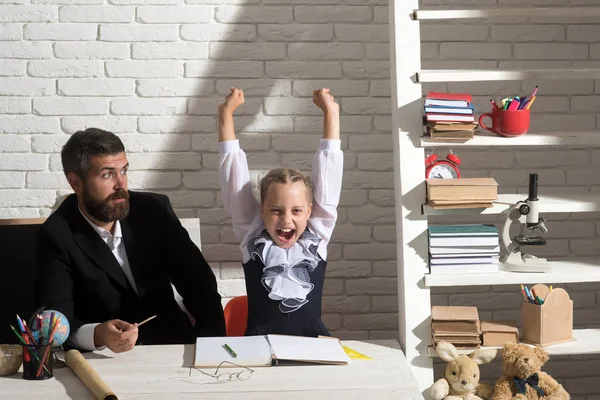 Filha e pai em sala de aula sobre fundo de tijolo branco — Fotografia de Stock