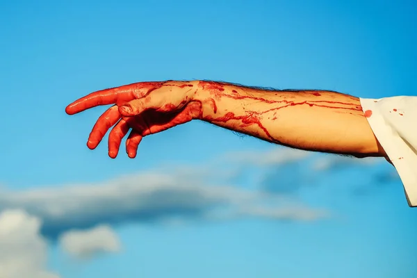 Sangrienta mano zombi con sangre roja en el cielo azul — Foto de Stock