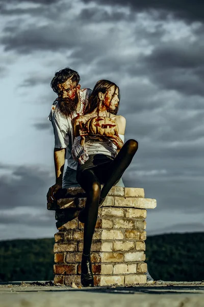 Halloween couple sitting on chimney — Stock Photo, Image