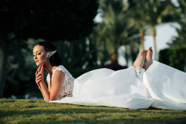 Kobieta leżąc na zielonej trawie na tropikalny krajobraz — Zdjęcie stockowe