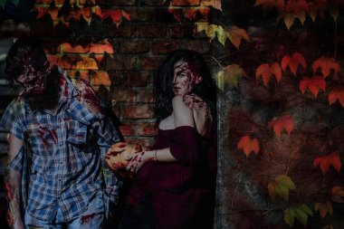 Halloween çift ayakta tuğla duvar ile sonbahar yaprakları
