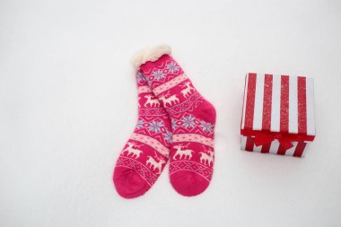 Çift çorap ve karlı zemin üzerine hediye kutusu