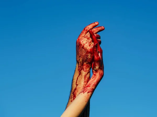 Sanguinose mani zombie con sangue rosso sul cielo blu — Foto Stock