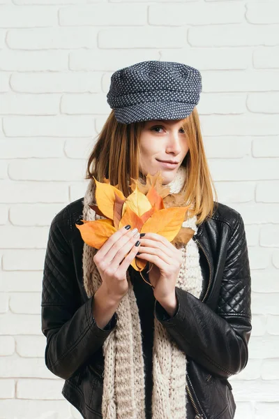 Kadın deri ceketli sonbahar yaprakları ile.