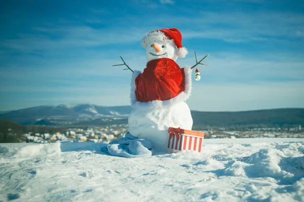 Χιονάνθρωπος με κόκκινο καπέλο Αϊ-Βασίλη. — Φωτογραφία Αρχείου