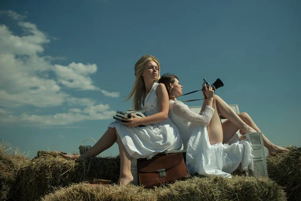 Freundinnen sitzen auf Bank bei blauem Himmel — Stockfoto