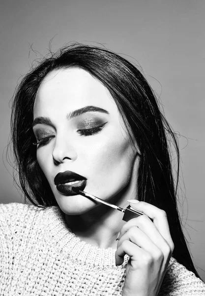 Kırmızı dudaklar ve uzun saçlı seksi kadınla tutun rimel