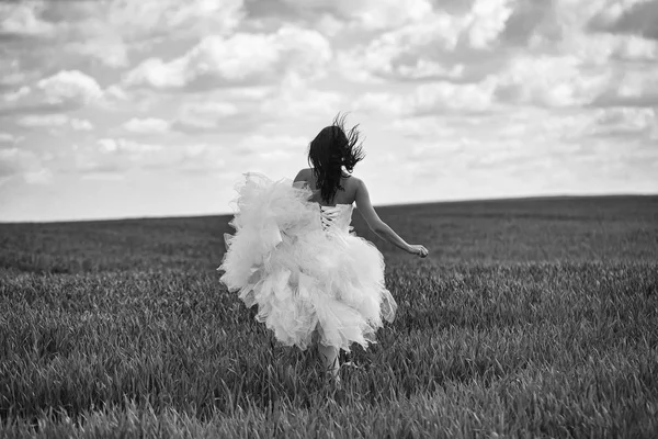 Hübsches Hochzeitsmädchen auf grünem Gras und Himmel — Stockfoto