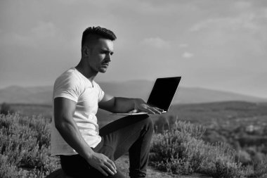 Dizüstü bilgisayar açık ile dalgın kaslı adam