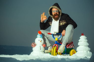 Mutlu adam gri gökyüzü üzerinde üç tekerlekli bisiklet sürme