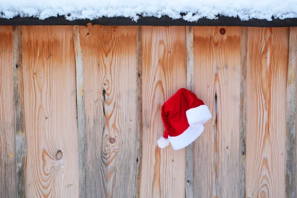 Santa claus şapka karlı çit üzerinde — Stok fotoğraf