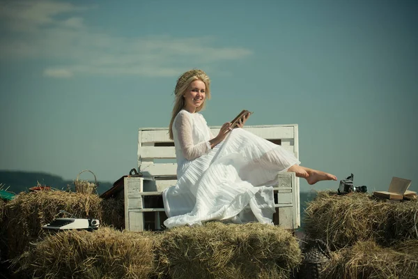 Mujer feliz leyendo libro en el banco en el cielo azul — Foto de Stock