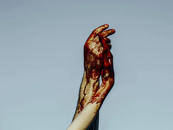 Хэллоуин кровавые руки держа на сером фоне неба — стоковое фото