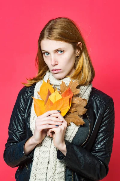 Kadın deri ceketli sonbahar yaprakları ile.