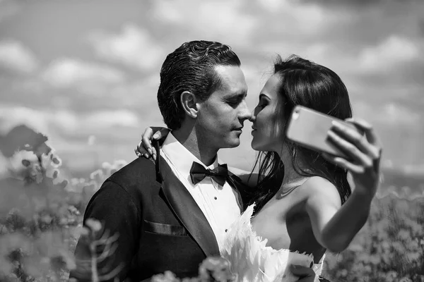 Casamento casal beijo no campo flores amarelas — Fotografia de Stock