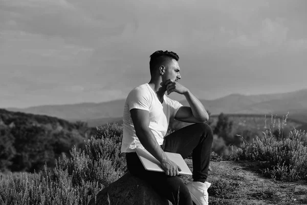 Hombre musculoso pensativo con portátil al aire libre —  Fotos de Stock