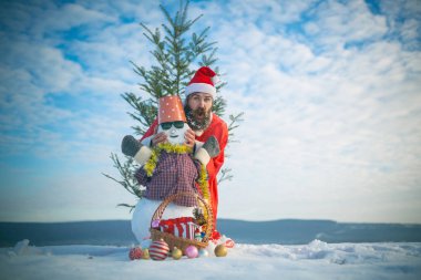 Bulutlu gökyüzü üzerinde karlı heykel ile poz adam