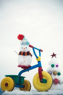 Kardan adam beyaz gökyüzü üzerinde üç tekerlekli bisiklet sürme