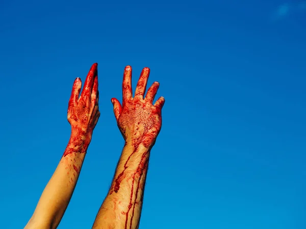 Sangrientas manos zombi con sangre roja en el cielo azul — Foto de Stock