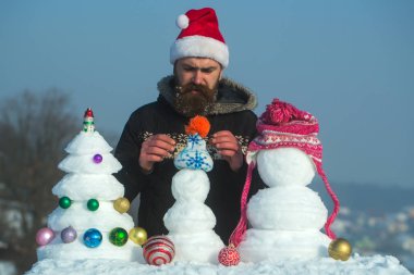 Kar xmas ağacı ve heykeller üzerinde mavi gökyüzü