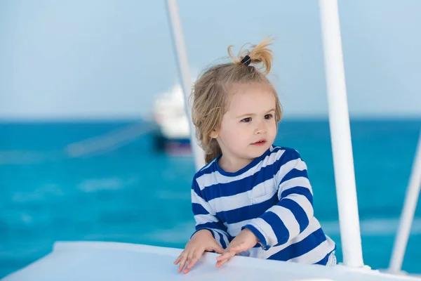 Criança em camisa listrada olhando para a água azul do oceano . — Fotografia de Stock