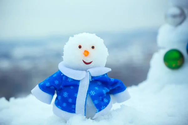 Schneeskulptur im blauen Mantel an einem Wintertag im Freien — Stockfoto