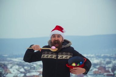 Kırmızı santa şapka ve paltosunu açık ağzına adamla