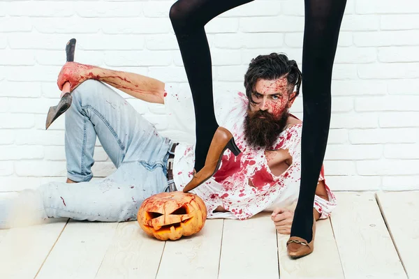 Halloween zombie bearded man with pumpkin, axe and female legs